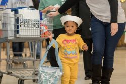 A child of a servicemember receives donated groceries from Food Lion at one of the grocer's recent "Season of Caring" events in Newport News, Va. (Photo: Business Wire)